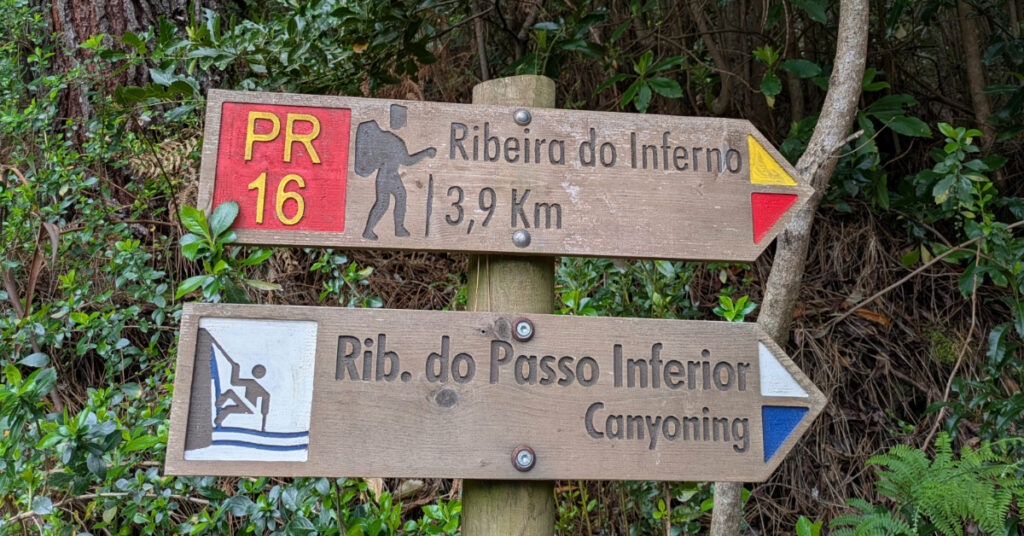 Signs pointing the way along PR16 to Ribeira do Inferno (3.9km) and Ribeira do Passo Inferior (canyoning).