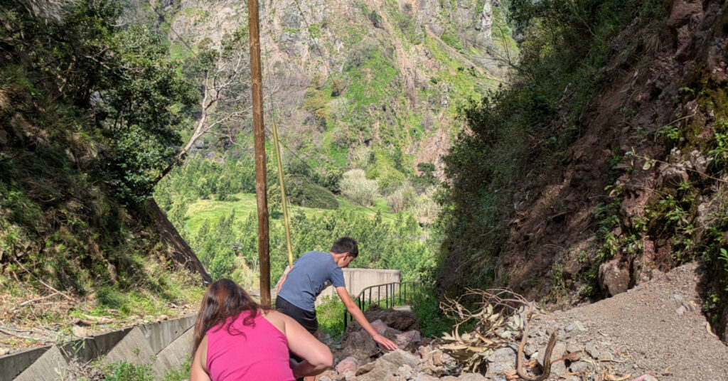 Alfie and Cheryl clamber over a rockfall that has covered the walkway.
