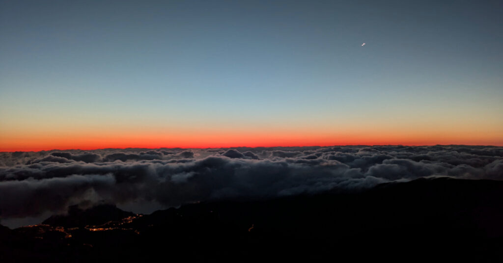 Dawn breaks over the sea of clouds, seen from the top of Pico do Areeiro.