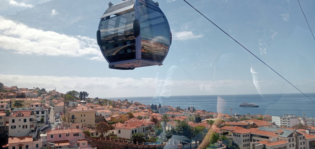 A cable car suspended over the orange-tiled roofs of Funchal
